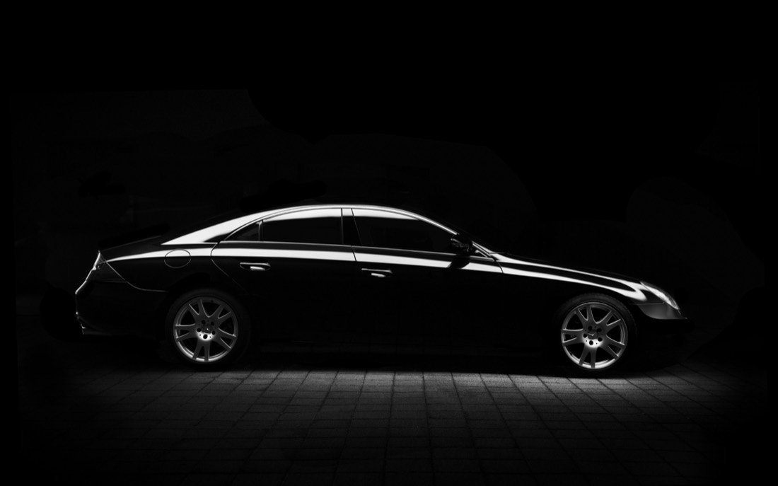 A luxury car lit against a dark background